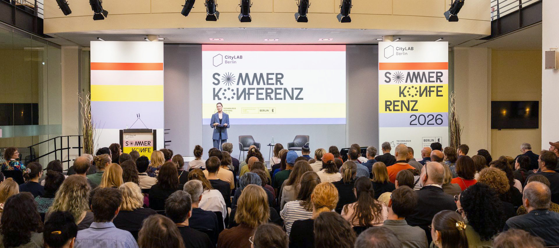 Vollbesetzter Konferenzsaal bei der CityLAB Sommerkonferenz 2026 in Berlin, Redner auf der Bühne