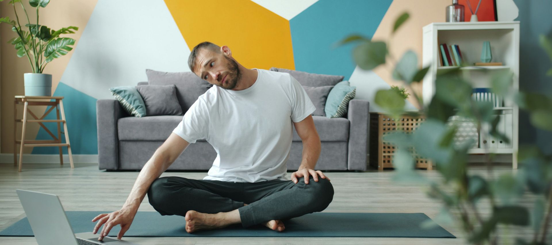 Teilnehmer eines digitalen Gesundheitsangebots trainiert zu Hause vor dem Laptop